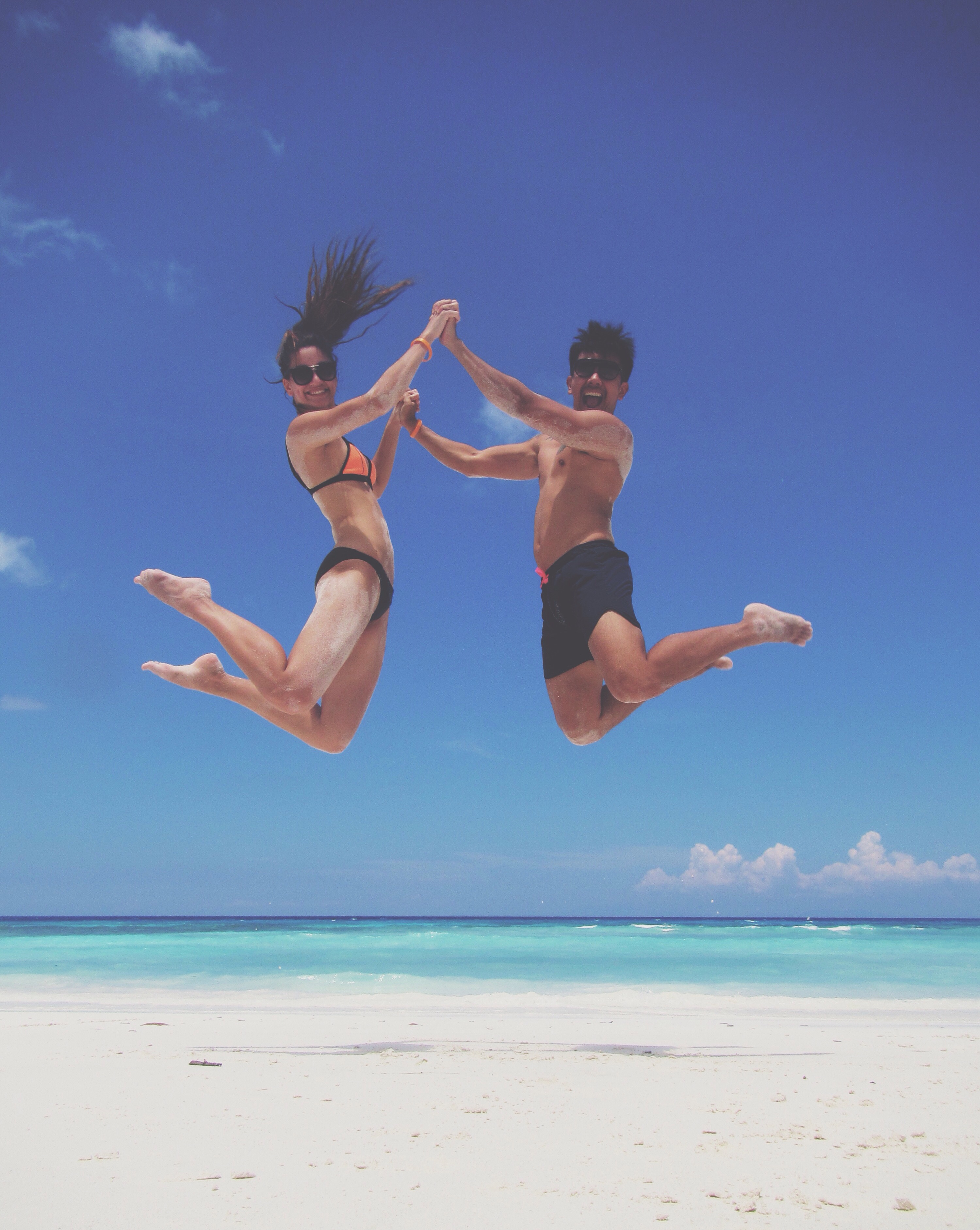 couple jumping on island tachai thailand