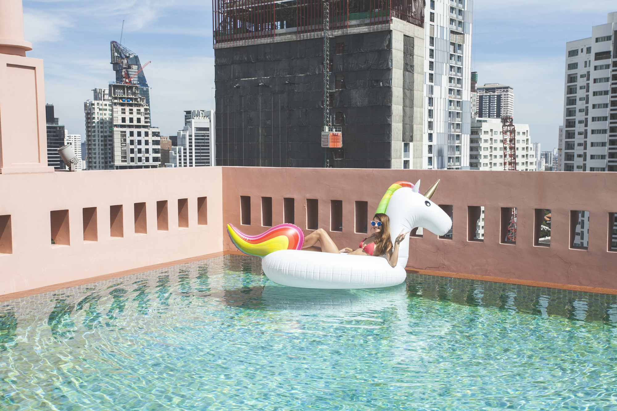 girl sitting unicorn in the pool