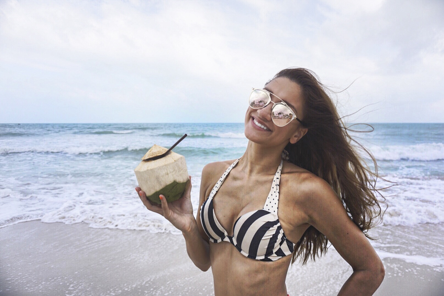 girl holding coconut on the beach koh samui