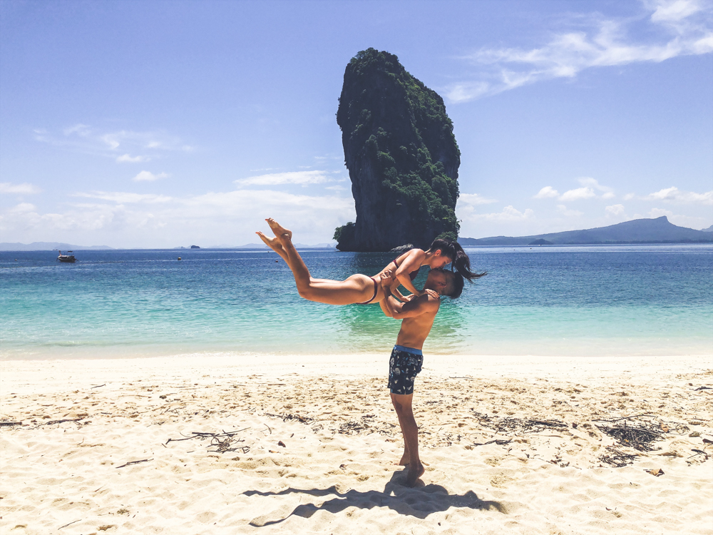 couple doing a leap kiss in front of koh poda in krabi